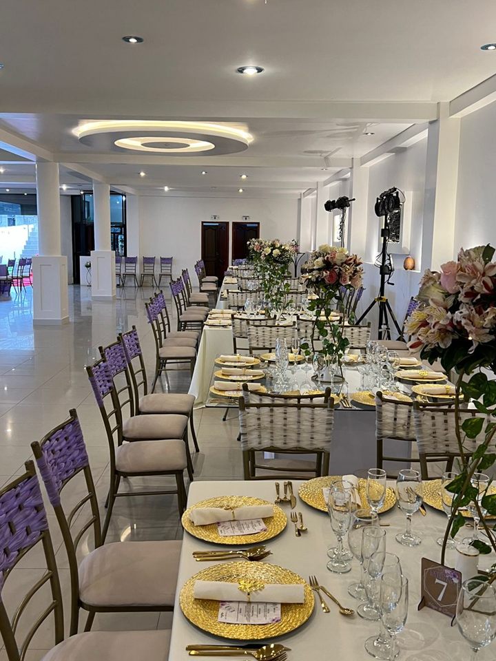 Banquete montado con mesas y sillas decoradas